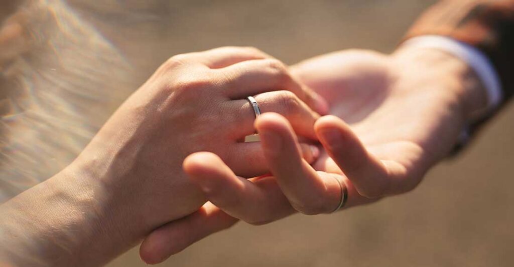 kadının alyans takan eli, adamın elinde, evlilik, Yabancı Bir Eşle Evlilik Sözleşmesi Nasıl Oluşturulur